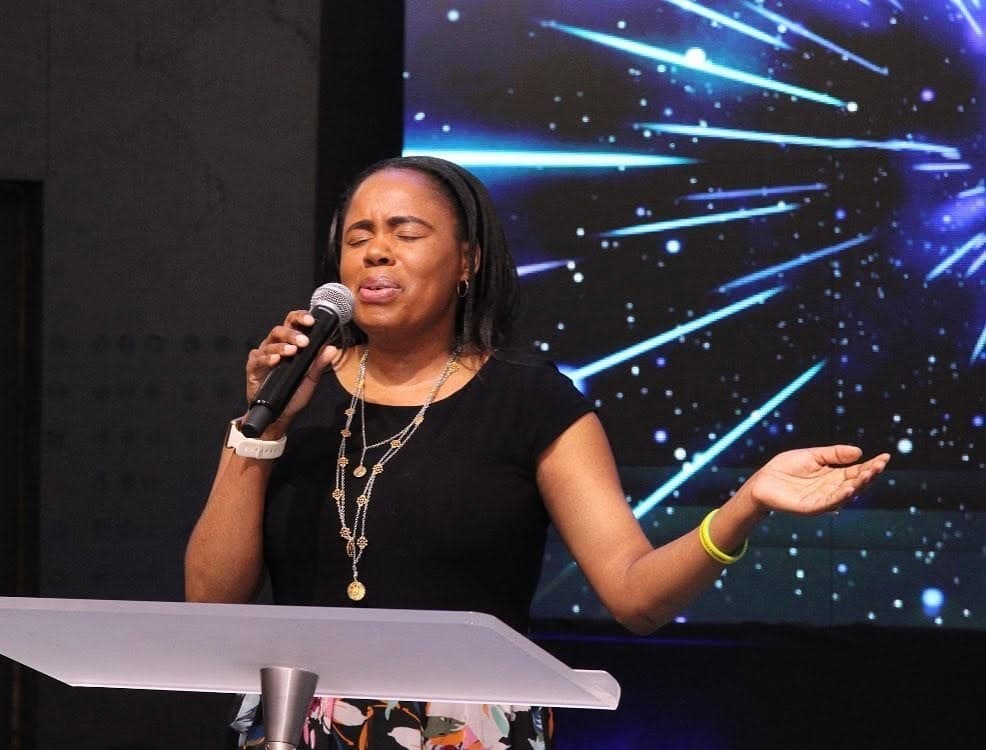 A worship leader sings from the platform